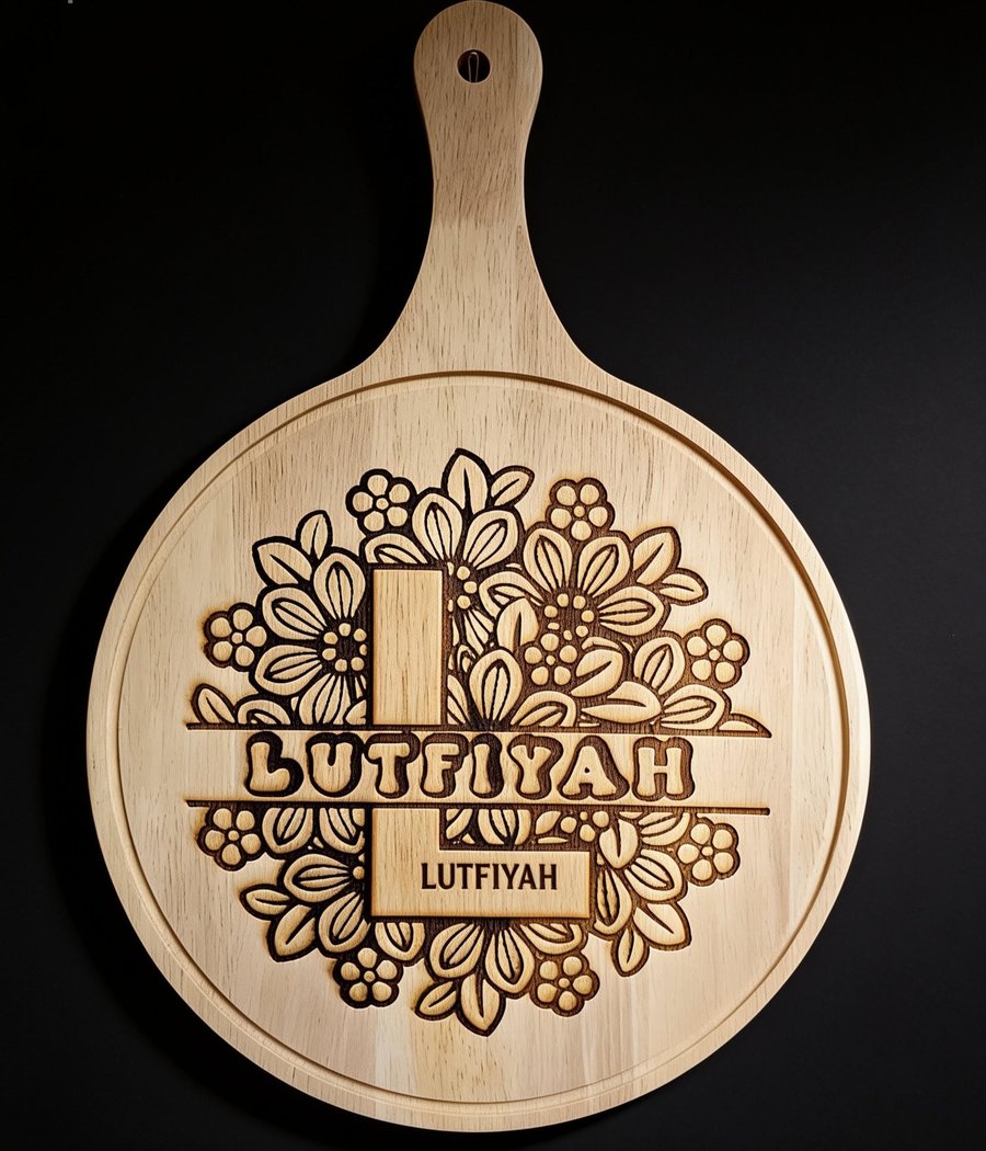 Round engraved wooden paddle board with floral design and the name Lutfiyah